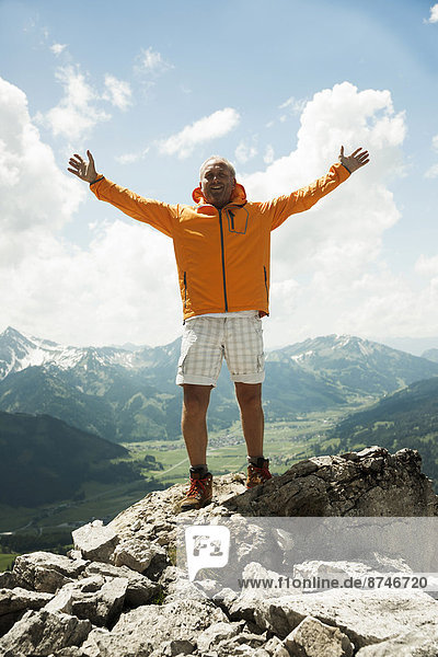 Mature man with arms raised in air  hiking in mountains  Tannheim Valley  Austria