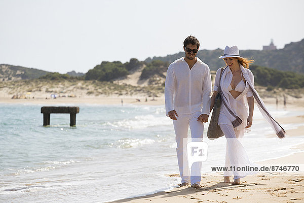 Young couple walking at the beach during summer holidays  Cala Cipolla  Chia Bay  Sardinia  Italy