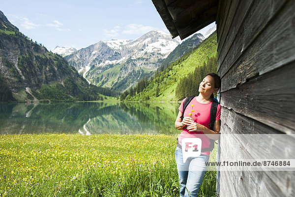Mature Woman Standing by Wooden Building  Vilsalpsee  Tannheim Valley  Tyrol  Austria