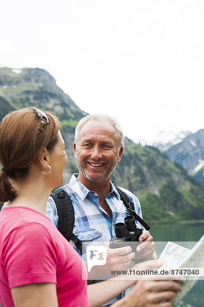 Close-up of mature couple looking at map  hiking in mountains  Lake Vilsalpsee  Tannheim Valley  Austria