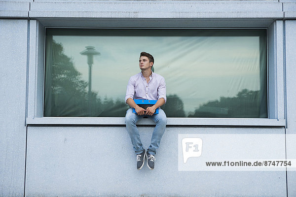 Außenaufnahme  sitzend  Mann  jung  Fenstersims  Deutschland  freie Natur