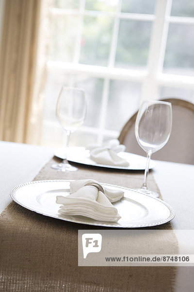 Simple and elegant place setting for two with plate charger and napkin