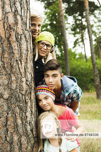 Portrait of group of children posing next to tree in park  Germany