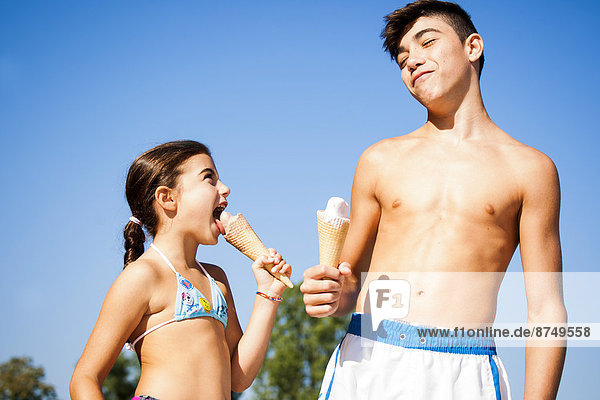 kegelförmig Kegel Junge - Person Eis essen essend isst Mädchen Sahne