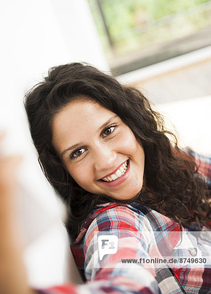Teenage girl smiling and posing  taking selfie with smart phone  Germany