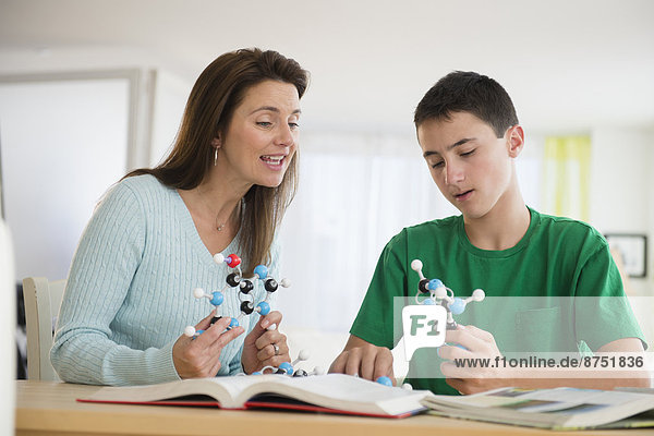 Caucasian mother and son studying atom models