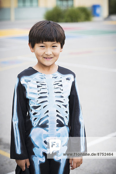 Portrait of Hispanic boy smiling in skeleton costume