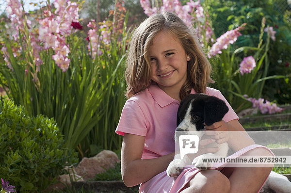 young girl with dog in garden
