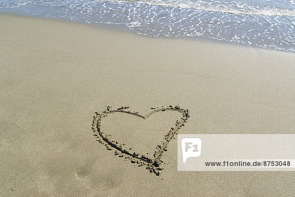 Spain Andalusia heart shape drawn in sand on beach