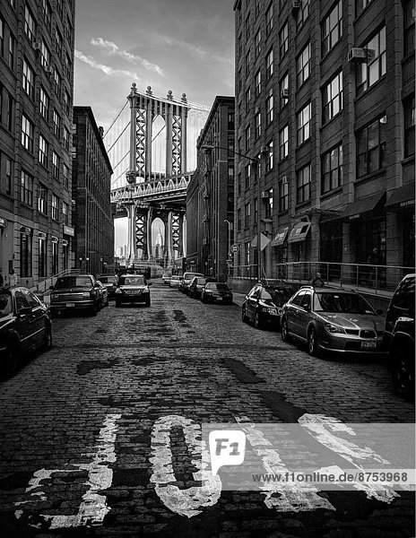 cobblestone street in Dumbo with the Manhattan Bride in background.