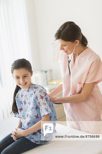 Doctor examining girl (8-9)