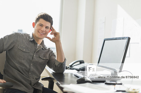 Young man sitting in front of desk