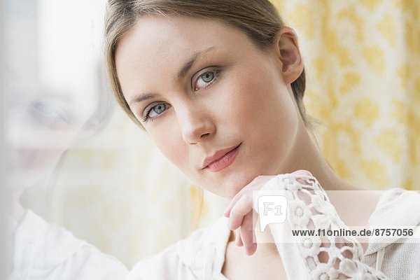 Portrait of young woman by window