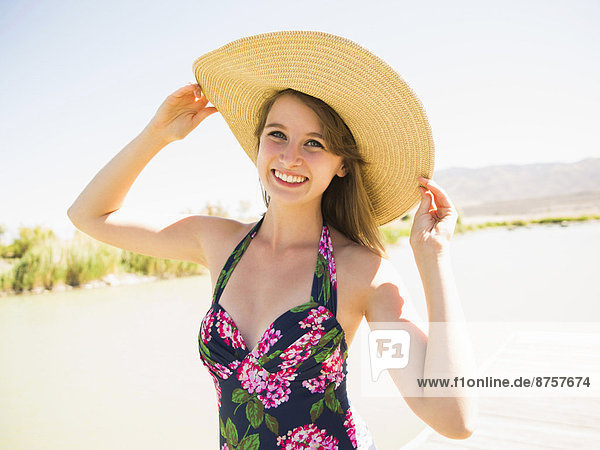 Portrait of young woman wearing sun hat on beach