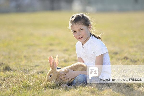 Mädchen mit ihren Kaninchen auf der Wiese  Oberpfalz  Bayern  Deutschland  Europa