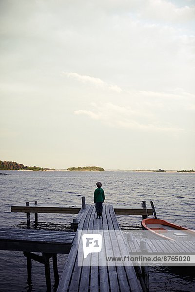 A boy standing on a jetty