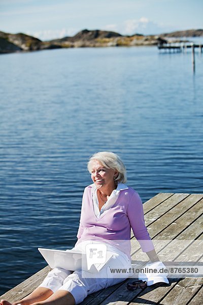 sitzend  Senior  Senioren  Frau  lächeln  Steg  Bohuslän  Schweden