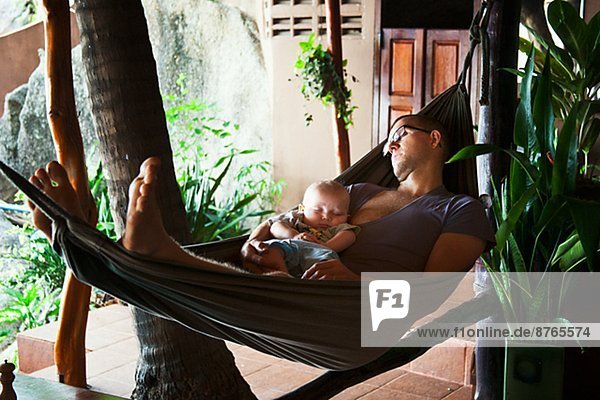 Father with baby seeping on hammock  Thailand
