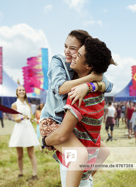 Enthusiastic couple hugging at music festival