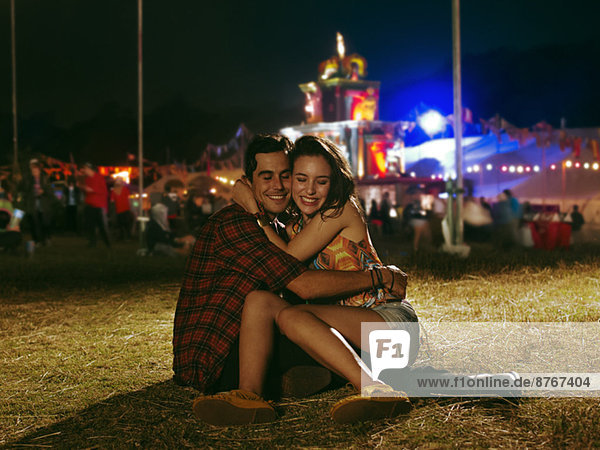 Ein glückliches Paar  das sich außerhalb des Musikfestivals umarmt.