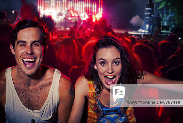 Enthusiastic couple cheering at music festival