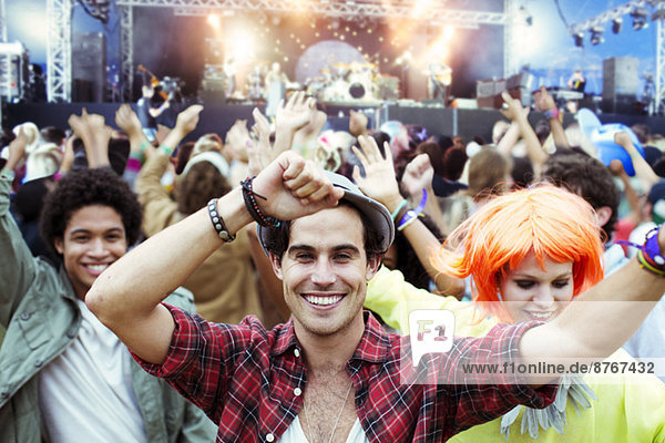 Portrait of fans dancing and cheering at music festival