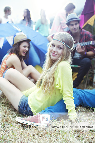 Portrait of woman hanging out with friends outside tents at music festival
