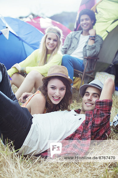 Portrait of friends hanging out outside of tents at music festival