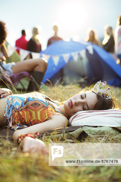 Frau im Diadem schlafend vor dem Zelt beim Musikfestival
