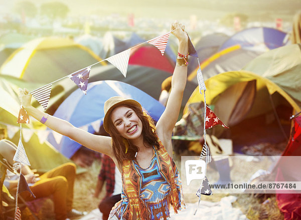 Porträt der begeisterten Frau vor den Zelten beim Musikfestival