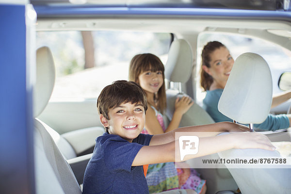Porträt einer glücklichen Familie im Auto