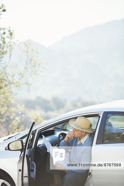 Älterer Mann beim Überprüfen der Karte im Auto