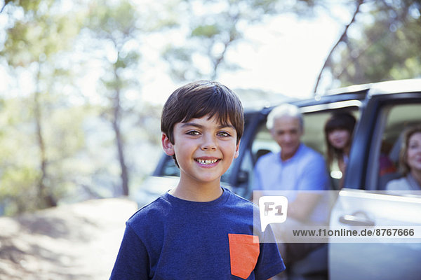 Porträt des lächelnden Jungen vor dem Auto