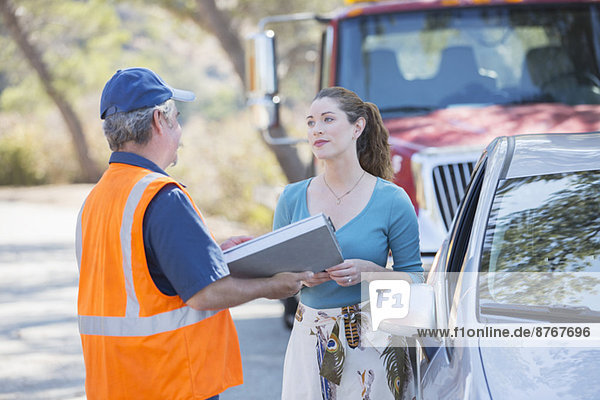Roadside mechanic talking with woman
