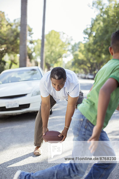 Großvater und Enkel spielen Fußball auf der Straße