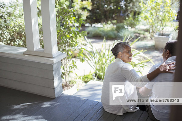 Seniorenpaar auf der Veranda umarmend