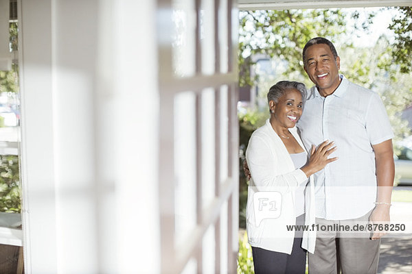 Porträt eines lächelnden Seniorenpaares im Eingangsbereich