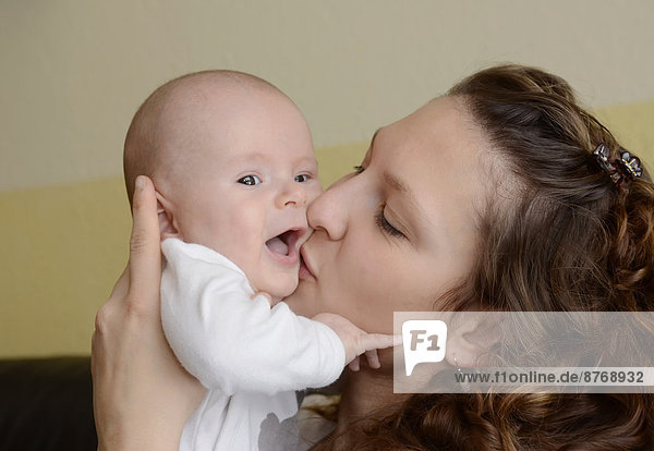 Mother kissing her happy baby boy