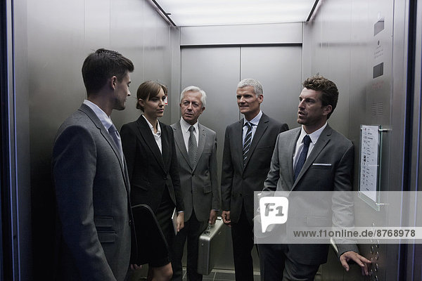 Group of businesspeople discussing in elevator