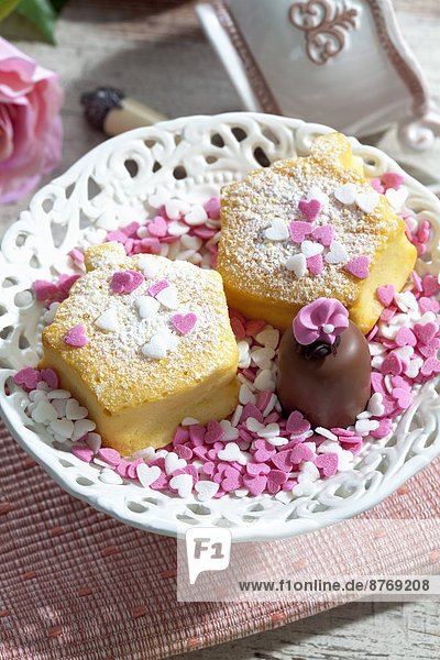 Zwei dekorierte Muffins  Schoko-Marshmallow und Zuckerherzen auf dem Teller