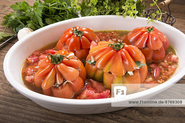 Filled beefsteak tomatoes in a gratin dish  raw  Low Carb