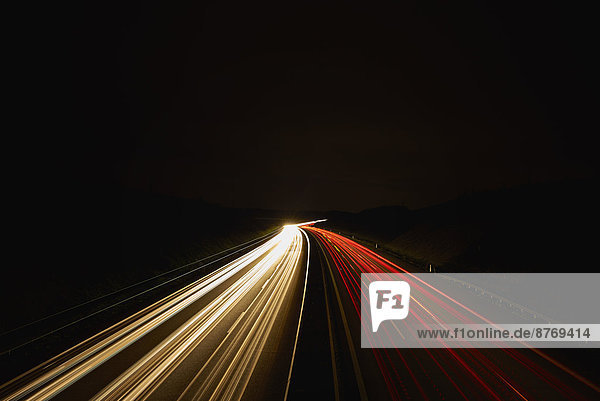 Deutschland  rote und weiße Lichtspuren auf der Autobahn bei Nacht  lange Belichtung
