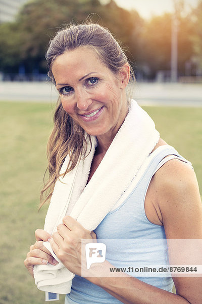 Sportive mature woman with towel around her neck