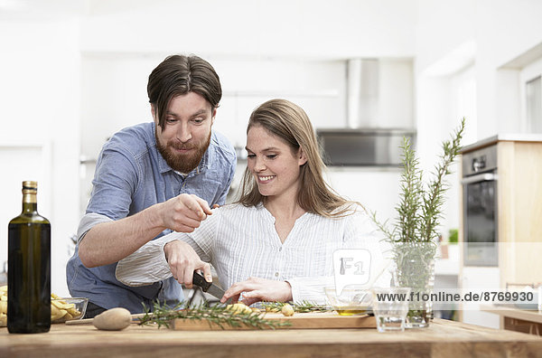 Happy couple preparing food in kitchen