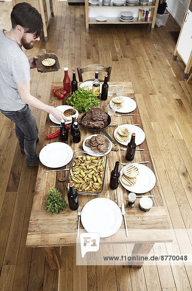 Man serving dish on wooden table