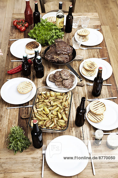 Gericht mit Kartoffeln  Steaks und Fleischbällchen auf Holztisch