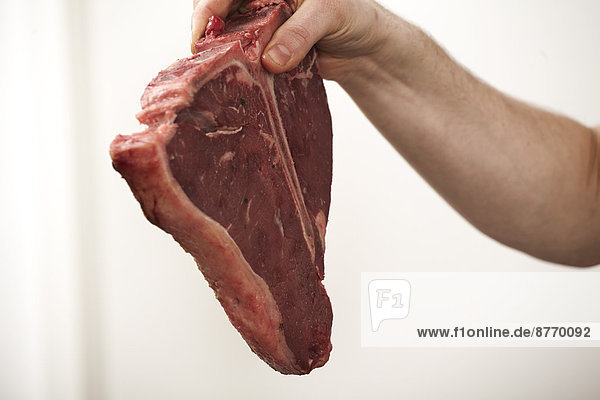 Close-up of man holding steak