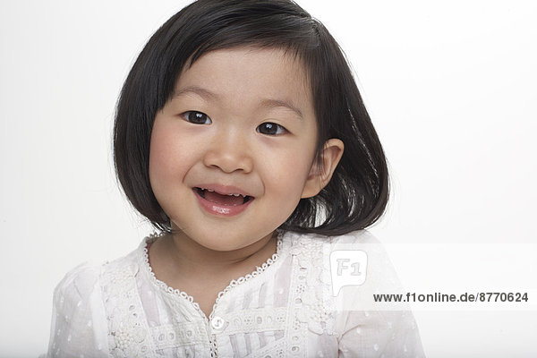 Portrait of little Asian girl smiling  studio shot