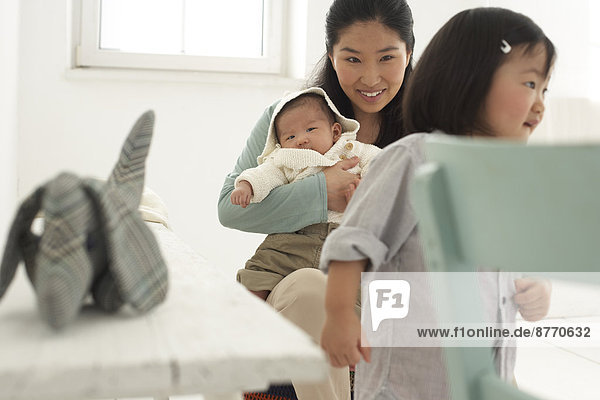 Asiatische Mutter mit Kleinkind und Baby