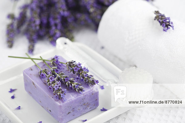 Lavendel (Lavendel),  Lavendelseife auf Seifenkorb,  weiße Handtuchrolle,  Bürste